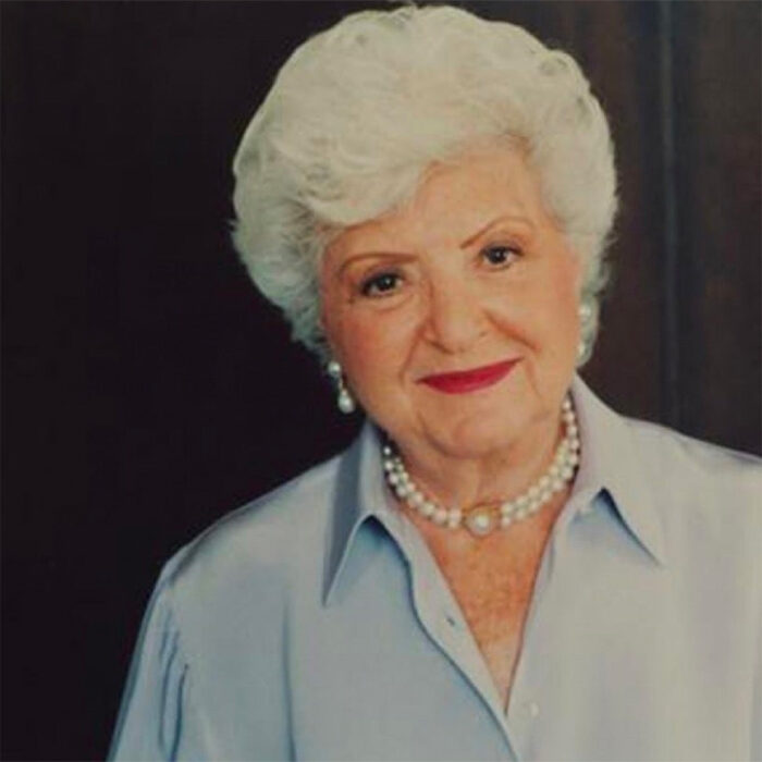 Porträtfoto von einer lächelnden Ruth Handler im fortgeschrittenen Alter mit Perlenschmuck und rotem Lippenstift