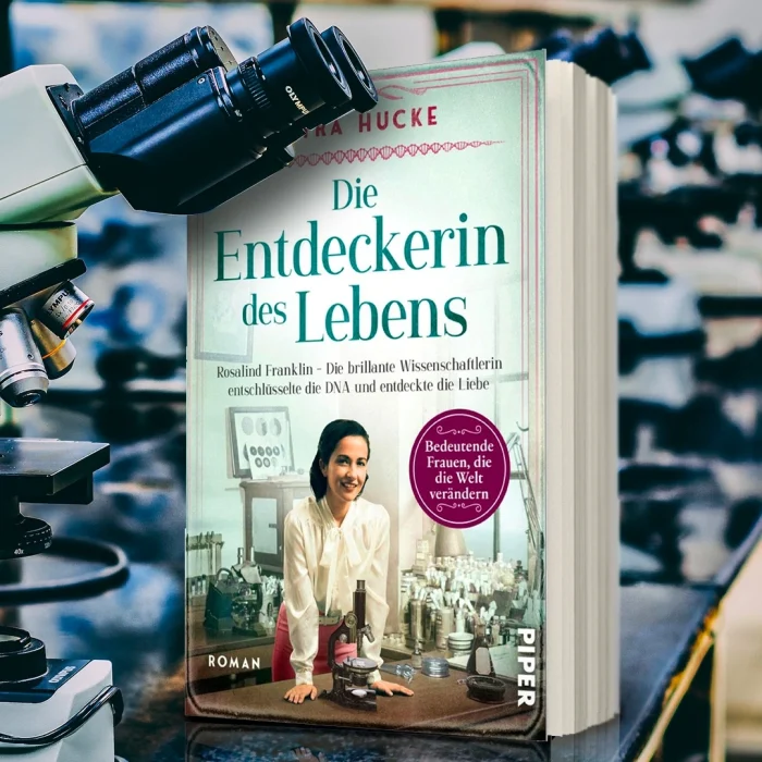 Buch "Die Entdeckerin des Lebens" von Petra Hucke neben einem Mikroskop im Chemielabor