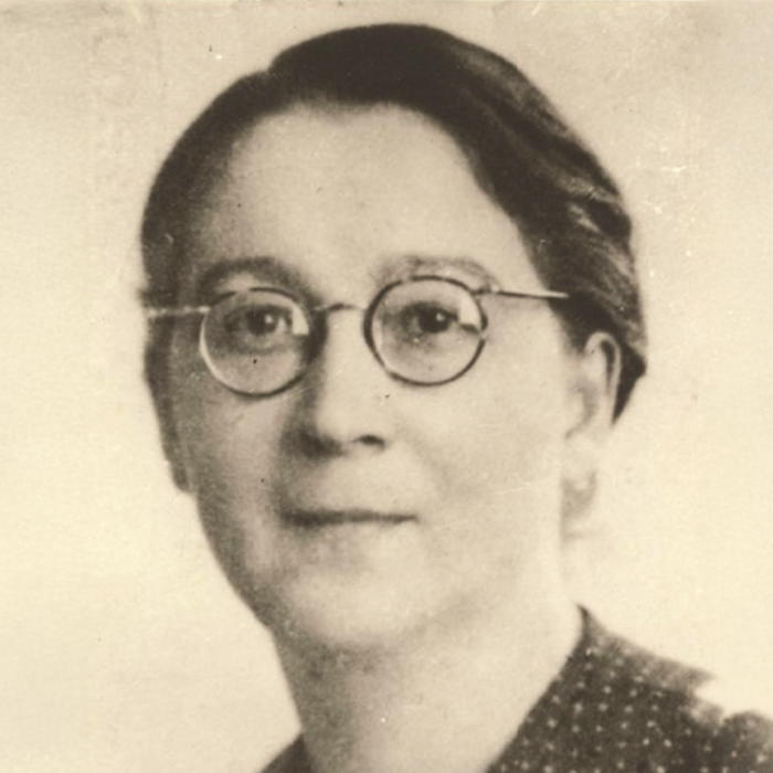 Porträtfoto von Rose Valland, die eine runde Nickelbrille trägt und in die Kamera lächelt.